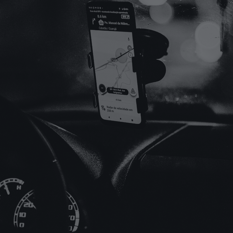 A mobile phone mounted to the windshield of a car