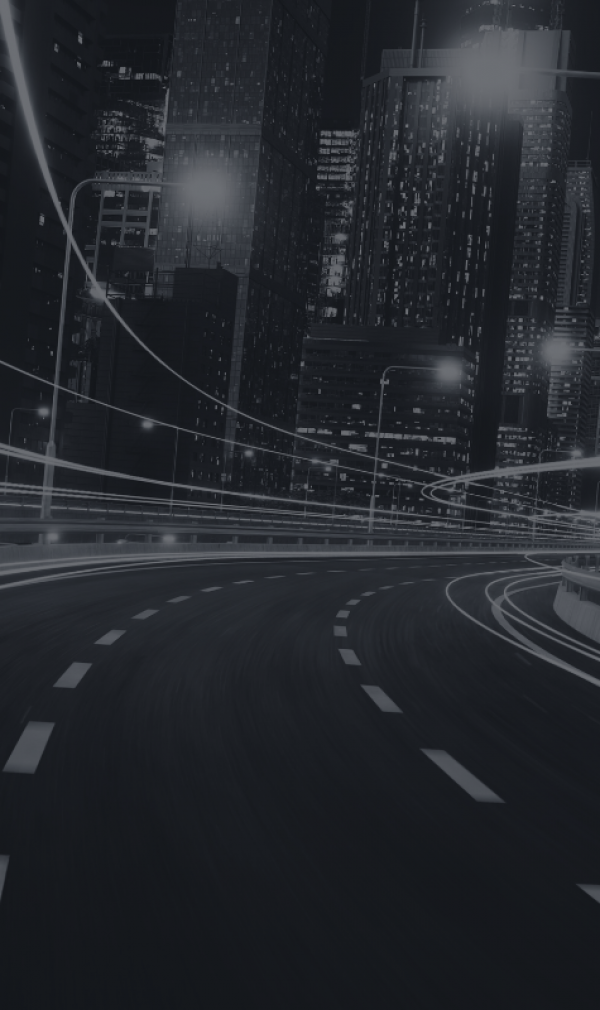 A driver's view of the road curving in a city at night